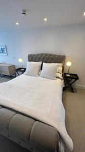 a large bed with white sheets and pillows on it at Morelli Plaza Portstewart in Portstewart +7 photos