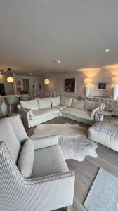 uma grande sala de estar com sofás brancos e mesas em Morelli Plaza Portstewart em Portstewart