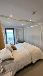 ein Schlafzimmer mit einem großen Bett und einem großen Fenster in der Unterkunft Morelli Plaza Portstewart in Portstewart