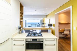 Modern Beach Front Apartment في باليتو: مطبخ مع موقد وإطلالة على المحيط