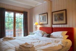 a bedroom with a bed with white sheets and a window at Chalet à Crans-Montana 17 personnes in Crans-Montana
