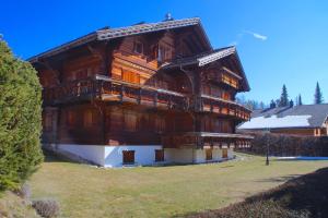 a large wooden building on a field of grass at Chalet à Crans-Montana 17 personnes in Crans-Montana