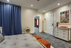a bedroom with a large bed and blue curtains at Charming Downtown Retreat Steps from Capitol Bldg in Harrisburg