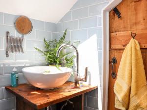 a bathroom with a white bowl sink on a wooden counter at The Barn at Trevothen Farm in Helston +29 photos