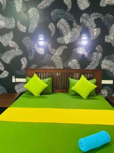 - une chambre avec un lit vert et un mur dans l'établissement thambara gueust house, à Habarana