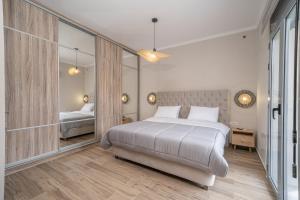 1 dormitorio con 1 cama grande y espejo en Maria Seaside Apartment en Sami