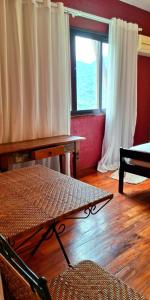 a living room with a table and a window at Pousada Terraço Penedo in Penedo