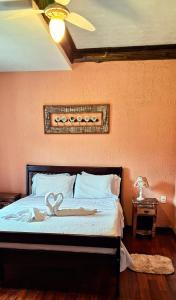 a bedroom with a bed with a heart decoration on it at Pousada Terraço Penedo in Penedo