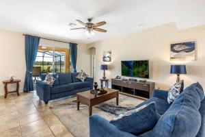 a living room with two blue couches and a tv at 535 -Villa Belvedere, A Stunning, Spacious 5 Bed Lake View Home with Pool and Spa in Davenport