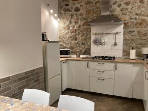 a kitchen with a white refrigerator and white cabinets at Tiny House in the center in Torri del Benaco