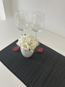 Due bicchieri di vino e una ciotola di cipolle su un tappetino nero. di Apartment Ferien Wohnung 4 a Gera