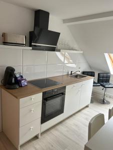 格拉的住宿－Apartment Ferien Wohnung 4，厨房配有白色橱柜和炉灶烤箱。