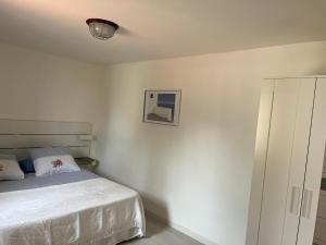 ein weißes Schlafzimmer mit einem Bett und einem Schrank in der Unterkunft Casa LiaLara Mare in Augusta