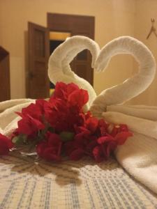 - un bouquet de fleurs rouges assises sur un lit et des serviettes dans l'établissement Village Lagoinha Ceará, à Paraipaba