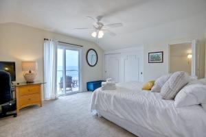 - une chambre avec un lit blanc et une télévision dans l'établissement Oceanfront 4BR, Private Beach & Patio, Remodeled Kitchen, à Oceanside