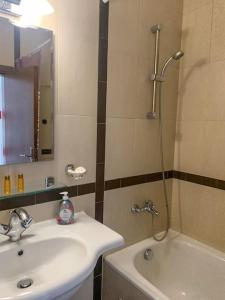 a bathroom with a sink and a shower and a tub at Cozy Rila Park Apartments in Borovets