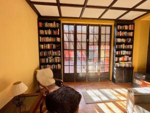 een woonkamer met boekenplanken, een stoel en een raam bij Hotel Rural Villa del Monte in Santa Brígida