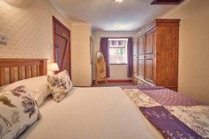 a bedroom with a large bed and a window at Host & Stay - Rose Cottage in Bamburgh