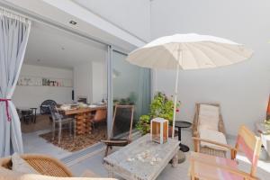 a living room with a table and an umbrella at BmyGuest - Meco Mar-Me-Quer House in Alfarim