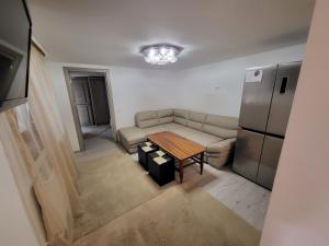 a living room with a couch and a table and a refrigerator at Casa Laura&Florin in Constanţa