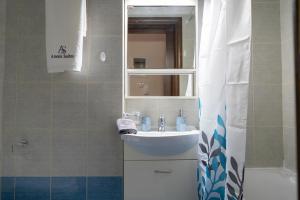 a bathroom with a sink and a mirror at Anesis Suites in Volos