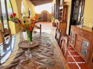 Hotel Rural Villa del Monte في سانتا بريخيذا: مزهرية من الزهور على طاولة في غرفة