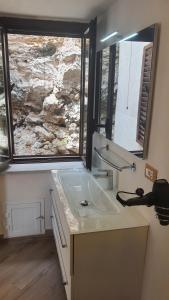 a bathroom with a sink and a large window at Sotto la Torre e sopra il Porticciolo in Ustica