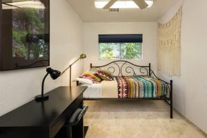 a bedroom with a bed with a desk and a window at Kapila Gardens Family Retreat w/ private pool in Cottonwood +63 photos