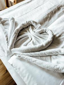 ein weißes Bett mit einem Handtuch drauf in der Unterkunft Der Gamsjäger in Gosau