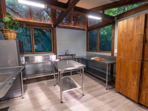 una cocina con mesas y ventanas de acero inoxidable en Ponta Membene, en Machavene