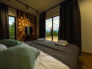 - une chambre avec un grand lit et une grande fenêtre dans l'établissement Carpathians View, à Krivopolʼye