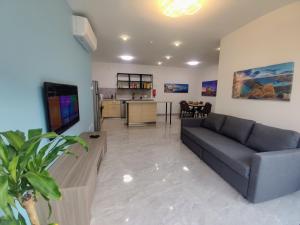 a living room with a couch and a kitchen at Deggies Apartments - spacious, modern apartment! in Naxxar