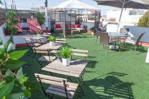 a patio with tables and chairs on a roof at Reservaloen Terrazas de la Catedral in Seville