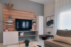 a living room with a flat screen tv on a wall at Hidden gem on the Piraeus Coast in Piraeus