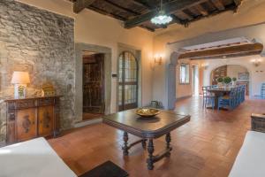 ein Wohnzimmer mit einem Tisch und einer Steinmauer in der Unterkunft Fonte Nuova in Badia Agnano