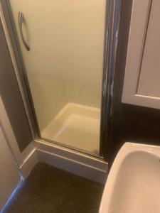 a bathroom with a shower with a toilet and a sink at Burnett Arms in Inverurie