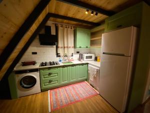 Yaka的住宿－Tlos Nature Houses，厨房配有绿色橱柜和白色冰箱