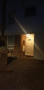 a white door in front of a brick building at night at Medway luxury Retreat free parking free wi-fi in Chatham