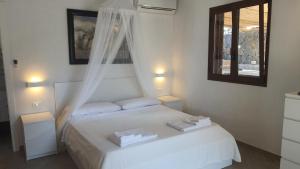 una camera da letto con un letto bianco con due asciugamani di Sotto la Torre e sopra il Porticciolo a Ustica