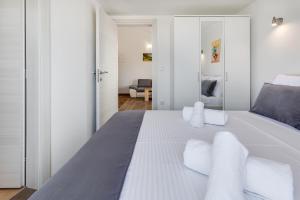 a white bedroom with a large bed with white pillows at Apartman David s bazenom i jakuzijem in Podušje +40 photos