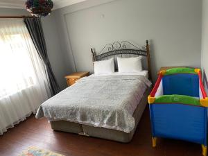 a bedroom with a bed and a colorful chair at Four seanson müstakil sıcak havuzlu villa in Sapanca