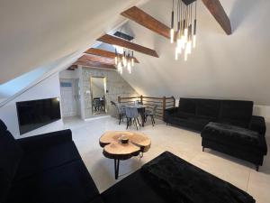 salon z czarnymi meblami i stołem w obiekcie APARTAMENT PIEKOSZOWSKA Targi Domek Parking w Kielcach
