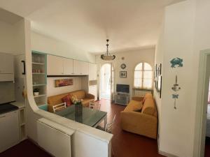 uma sala de estar com um sofá e uma mesa em Casa La Perla - Alloggio con terrazza panoramica, piscina e free parking em Ceriale