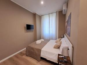 ein Schlafzimmer mit einem Bett und einem TV an der Wand in der Unterkunft Relais di gusto in La Spezia