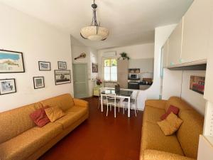 uma sala de estar com 2 sofás e uma sala de jantar em Casa La Perla - Alloggio con terrazza panoramica, piscina e free parking em Ceriale