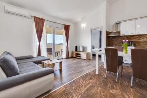 a living room with a couch and a table at Apartman David s bazenom i jakuzijem in Podušje