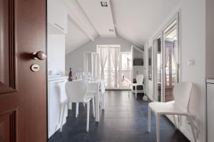 uma sala de jantar com cadeiras brancas e uma mesa em Amarea em Messina