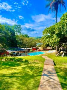 un chemin menant à une piscine dans un parc dans l'établissement Pousada Capitour, à São José da Barra