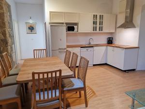 une cuisine avec une table et des chaises et une cuisine avec des placards blancs dans l'établissement Spacious 140m2 Downtown 3 Bedroom Apartment, à Split