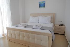 een slaapkamer met een groot bed met twee handdoeken erop bij Golden Berden Boutique Apart-Hotel in Çukë